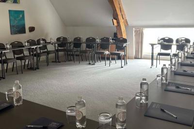 Comptoir en bois avec étagères contenant des bouteilles, tasses, objets décoratifs et plantes dans un espace lumineux.