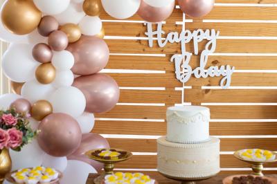 Un couple marche dans un champ au coucher du soleil, la femme portant une robe blanche et tenant légèrement son ourlet.