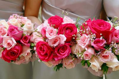 Un couple marche dans un champ au coucher du soleil, la femme portant une robe blanche et tenant légèrement son ourlet.