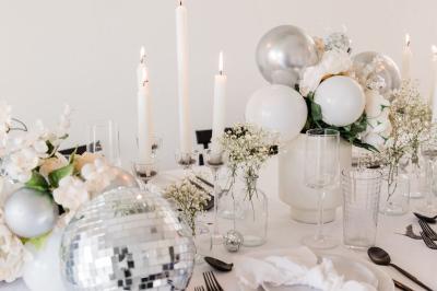Un couple marche dans un champ au coucher du soleil, la femme portant une robe blanche et tenant légèrement son ourlet.