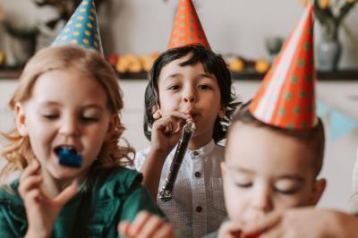 Un couple marche dans un champ au coucher du soleil, la femme portant une robe blanche et tenant légèrement son ourlet.
