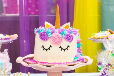 Un couple marche dans un champ au coucher du soleil, la femme portant une robe blanche et tenant légèrement son ourlet.