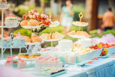 Un couple marche dans un champ au coucher du soleil, la femme portant une robe blanche et tenant légèrement son ourlet.