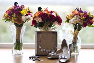 Un couple marche dans un champ au coucher du soleil, la femme portant une robe blanche et tenant légèrement son ourlet.