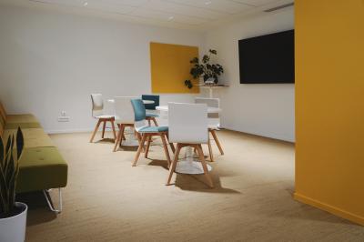 Mur en pierre orné d'une mosaïque colorée représentant un motif circulaire, entouré de végétation.