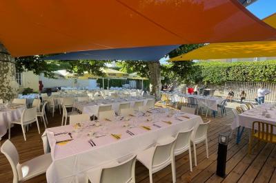 Mur en pierre orné d'une mosaïque colorée représentant un motif circulaire, entouré de végétation.