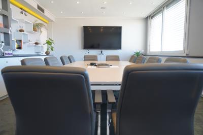 Mur en pierre orné d'une mosaïque colorée représentant un motif circulaire, entouré de végétation.