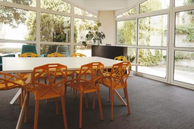 Mur en pierre orné d'une mosaïque colorée représentant un motif circulaire, entouré de végétation.