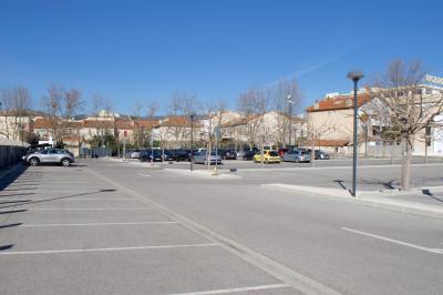 Mur en pierre orné d'une mosaïque colorée représentant un motif circulaire, entouré de végétation.