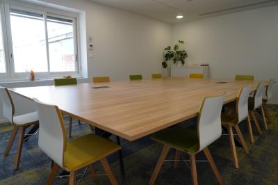 Mur en pierre orné d'une mosaïque colorée représentant un motif circulaire, entouré de végétation.