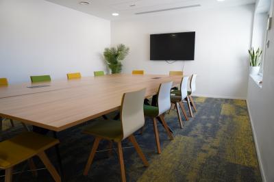 Mur en pierre orné d'une mosaïque colorée représentant un motif circulaire, entouré de végétation.