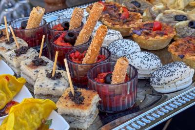 Mur en pierre orné d'une mosaïque colorée représentant un motif circulaire, entouré de végétation.