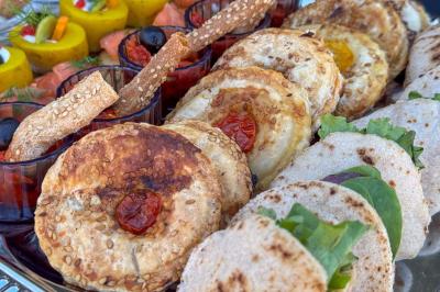 Mur en pierre orné d'une mosaïque colorée représentant un motif circulaire, entouré de végétation.