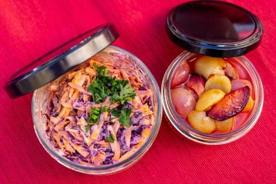 Mur en pierre orné d'une mosaïque colorée représentant un motif circulaire, entouré de végétation.