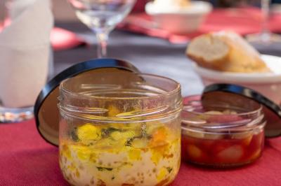 Mur en pierre orné d'une mosaïque colorée représentant un motif circulaire, entouré de végétation.