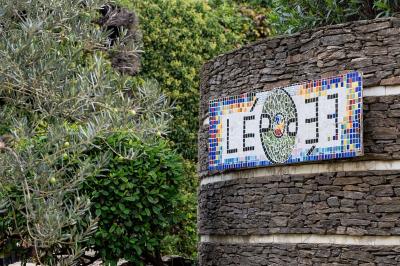 Mur en pierre orné d'une mosaïque colorée représentant un motif circulaire, entouré de végétation.