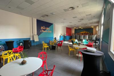 Mur en pierre orné d'une mosaïque colorée représentant un motif circulaire, entouré de végétation.