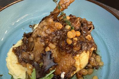 Un groupe d'hommes en tenues traditionnelles pose devant une décoration orientale et une affiche promotionnelle.