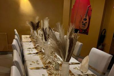 Un groupe d'hommes en tenues traditionnelles pose devant une décoration orientale et une affiche promotionnelle.