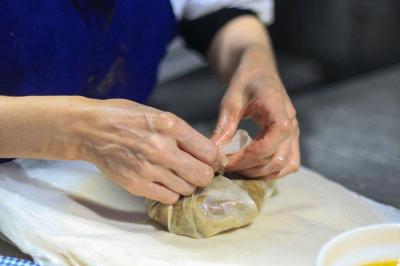Un groupe d'hommes en tenues traditionnelles pose devant une décoration orientale et une affiche promotionnelle.