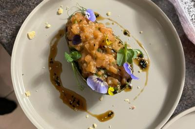 Bougies allumées et fleurs blanches disposées sur une table décorée pour un événement dans une ambiance tamisée.