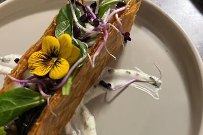 Bougies allumées et fleurs blanches disposées sur une table décorée pour un événement dans une ambiance tamisée.