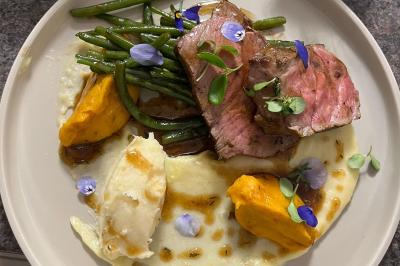 Bougies allumées et fleurs blanches disposées sur une table décorée pour un événement dans une ambiance tamisée.