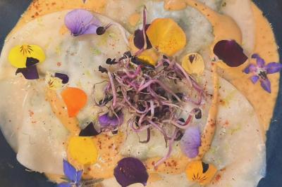 Bougies allumées et fleurs blanches disposées sur une table décorée pour un événement dans une ambiance tamisée.