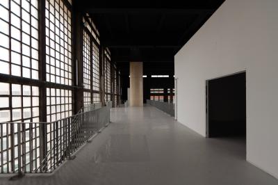 Vue d'un parking vide en extérieur, entouré de bâtiments modernes sous un ciel partiellement nuageux.