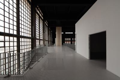 Vue d'un parking vide en extérieur, entouré de bâtiments modernes sous un ciel partiellement nuageux.