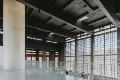 Vue d'un parking vide en extérieur, entouré de bâtiments modernes sous un ciel partiellement nuageux.