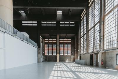 Vue d'un parking vide en extérieur, entouré de bâtiments modernes sous un ciel partiellement nuageux.