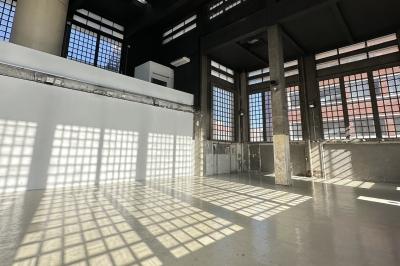 Vue d'un parking vide en extérieur, entouré de bâtiments modernes sous un ciel partiellement nuageux.