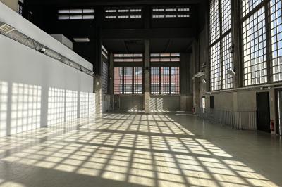 Vue d'un parking vide en extérieur, entouré de bâtiments modernes sous un ciel partiellement nuageux.