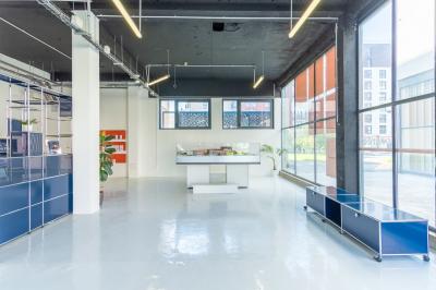 Vue d'un parking vide en extérieur, entouré de bâtiments modernes sous un ciel partiellement nuageux.