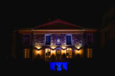 Décor de cérémonie en extérieur avec arche en bois, voilages blancs et verts, fleurs et chaises en bois.