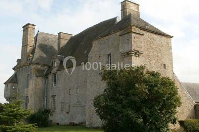 Cuisine rustique avec évier double, plan de travail en inox, réfrigérateur, cuisinière et mur en pierre apparente.