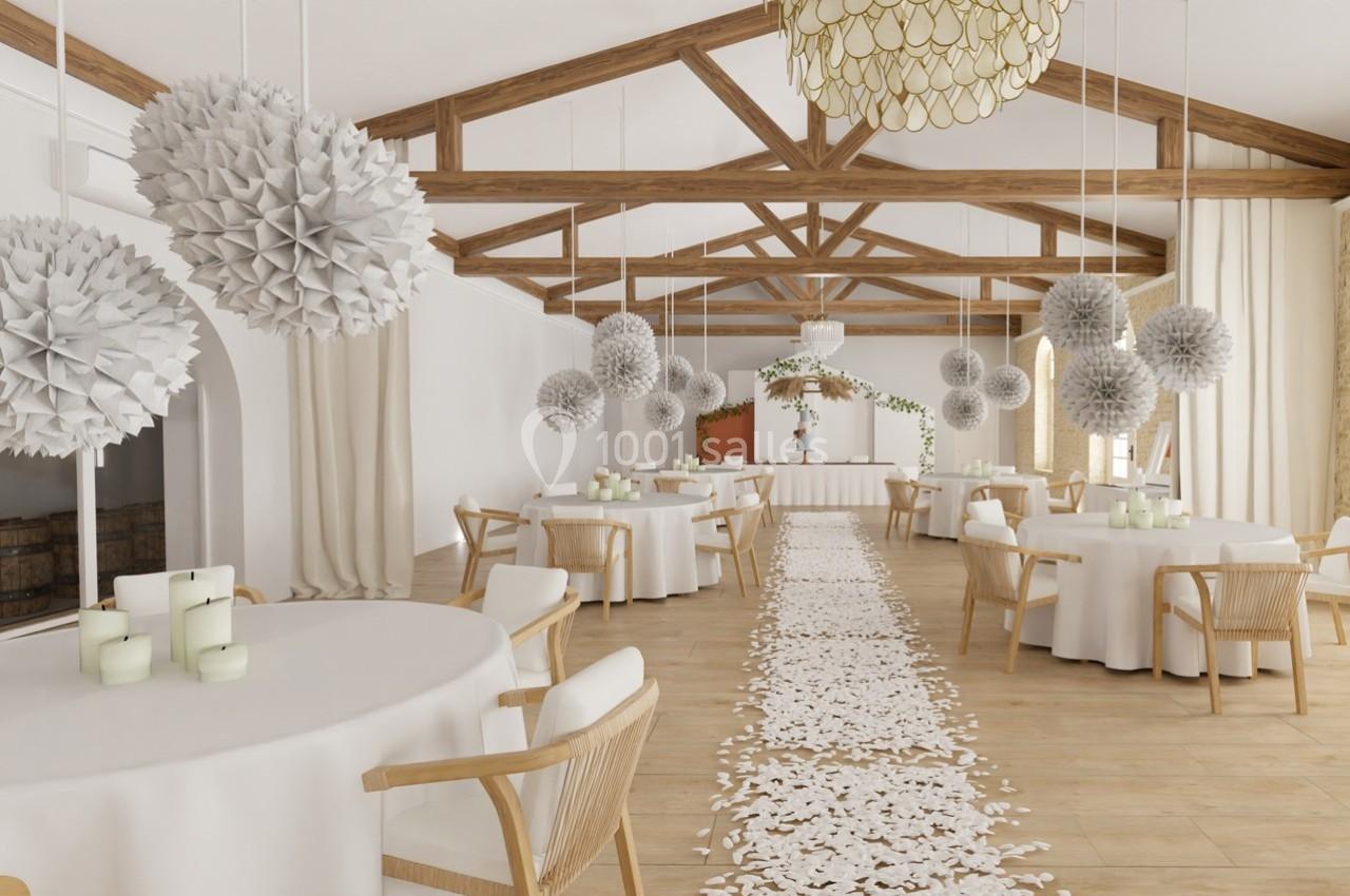 Salle de réception lumineuse avec tables rondes décorées, guirlandes suspendues et allée ornée de pétales blancs.