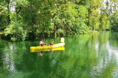 Intérieur d'un bar cosy avec un comptoir en bois, des tabourets hauts et des tables alignées dans un espace chaleureux.