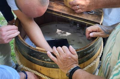 Intérieur d'un bar cosy avec un comptoir en bois, des tabourets hauts et des tables alignées dans un espace chaleureux.