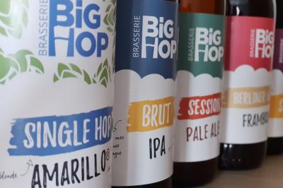 Intérieur d'un bar cosy avec un comptoir en bois, des tabourets hauts et des tables alignées dans un espace chaleureux.