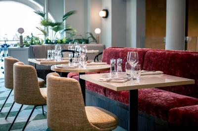 Deux machines à sous lumineuses avec écrans colorés, une personne assise devant l'une d'elles dans un casino.