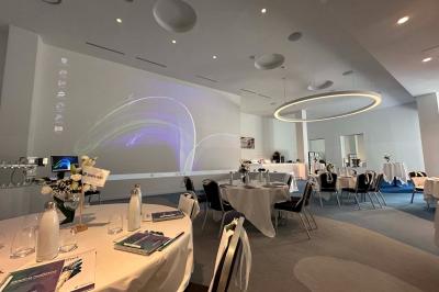 Deux machines à sous lumineuses avec écrans colorés, une personne assise devant l'une d'elles dans un casino.