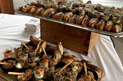 Assortiment de grillades, samoussas, légumes et sauce, garni d'oignons et tomates cerises.