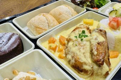 Assortiment de grillades, samoussas, légumes et sauce, garni d'oignons et tomates cerises.