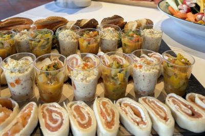 Assortiment de grillades, samoussas, légumes et sauce, garni d'oignons et tomates cerises.