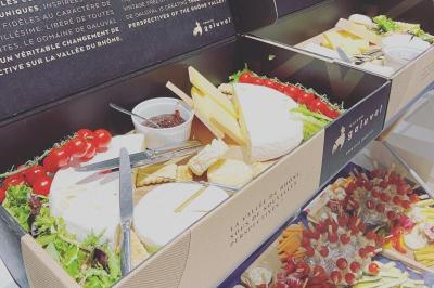 Assortiment de grillades, samoussas, légumes et sauce, garni d'oignons et tomates cerises.