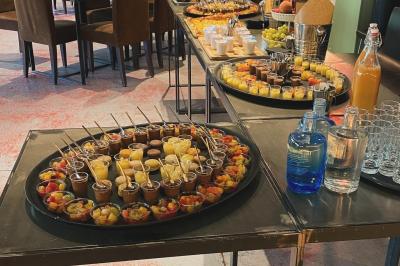 Assortiment de grillades, samoussas, légumes et sauce, garni d'oignons et tomates cerises.