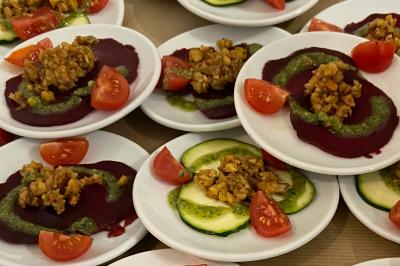 Assortiment de grillades, samoussas, légumes et sauce, garni d'oignons et tomates cerises.