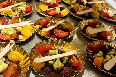 Assortiment de grillades, samoussas, légumes et sauce, garni d'oignons et tomates cerises.